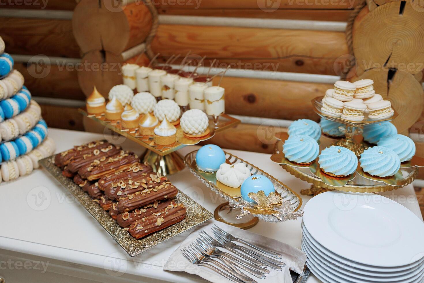 A table with a variety of desserts, including macaroons, cupcakes photo