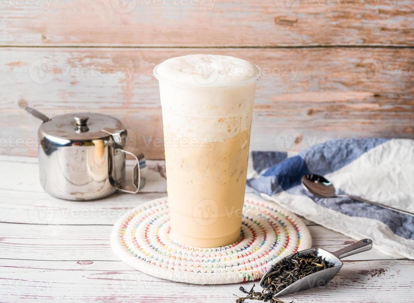 Iced Jasmine Green Milk Tea with sugar pot and spoon served in disposable glass isolated on table side view of hong kong tea photo
