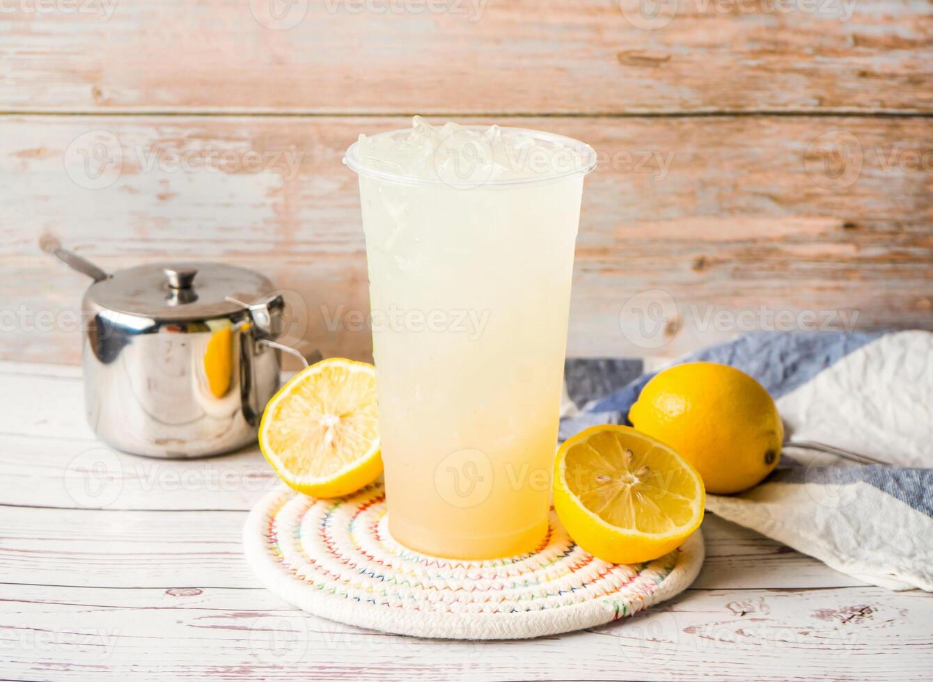 Iced Light Lemon Juice with sugar pot and spoon served in disposable glass isolated on table side view of hong kong tea photo