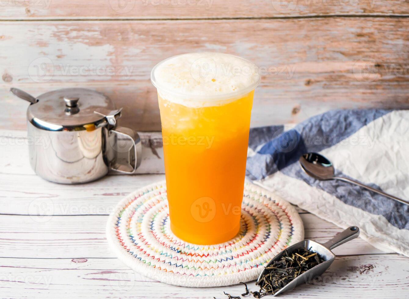 Iced Taiwan Green Tea with sugar pot and spoon served in disposable glass isolated on table side view of hong kong tea photo