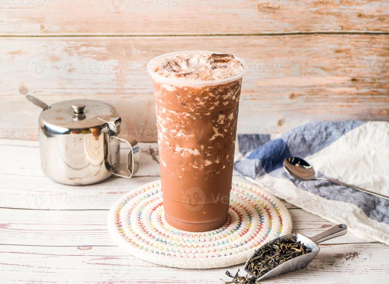 Iced Chocolate Milk Tea with sugar pot and spoon served in disposable glass isolated on table side view of hong kong tea photo