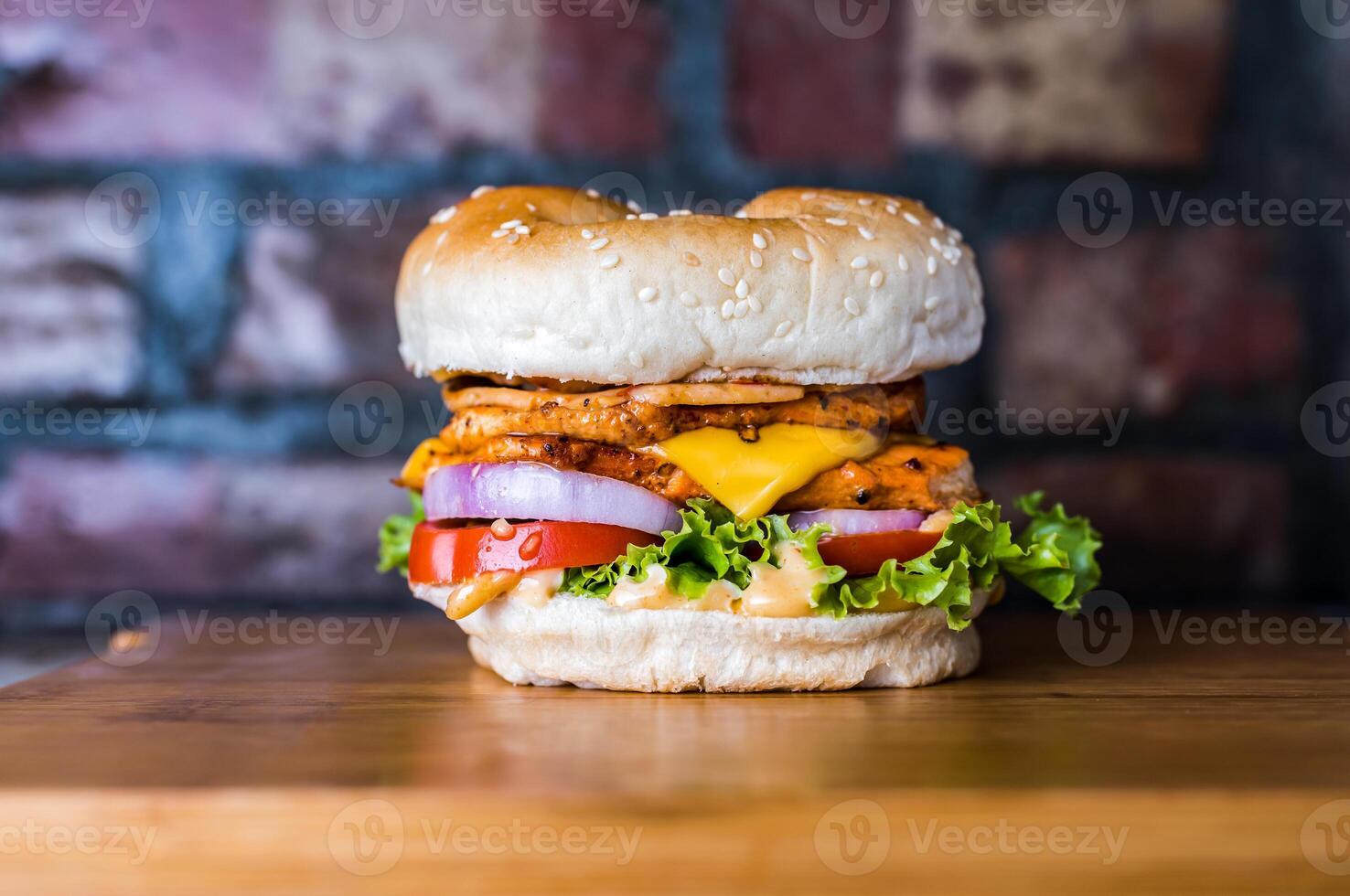 Double Chicken cheese premium Burger include chicken patty, mayonnaise, lettuce leaf, tomato and onion isolated on wooden board side view of unhealthy junk fastfood photo