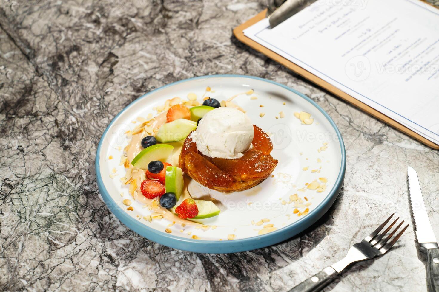 Traditional French Apple Batch or Tarte Tatin with straberry, blackberry, dip, fork and knife served in plate isolated on marble background side view of hong kong baked dessert food photo