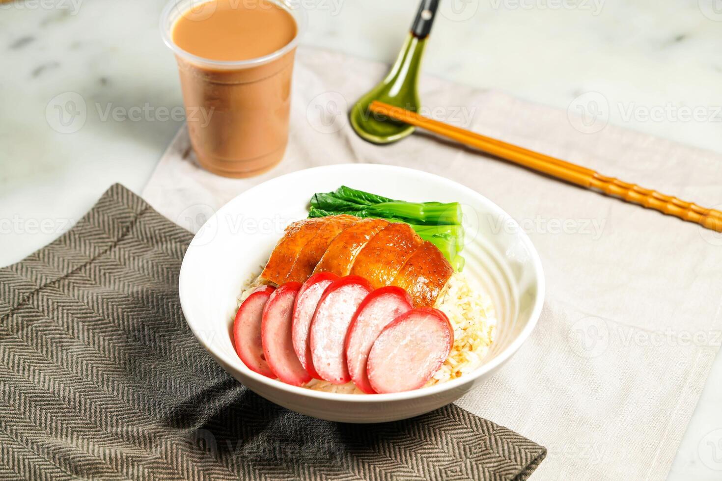 Chinese Sausage and Soya Chicken with Rice with milk kopi chopsticks and spoon served in bowl isolated on napkin side view of hong kong food on marble background photo