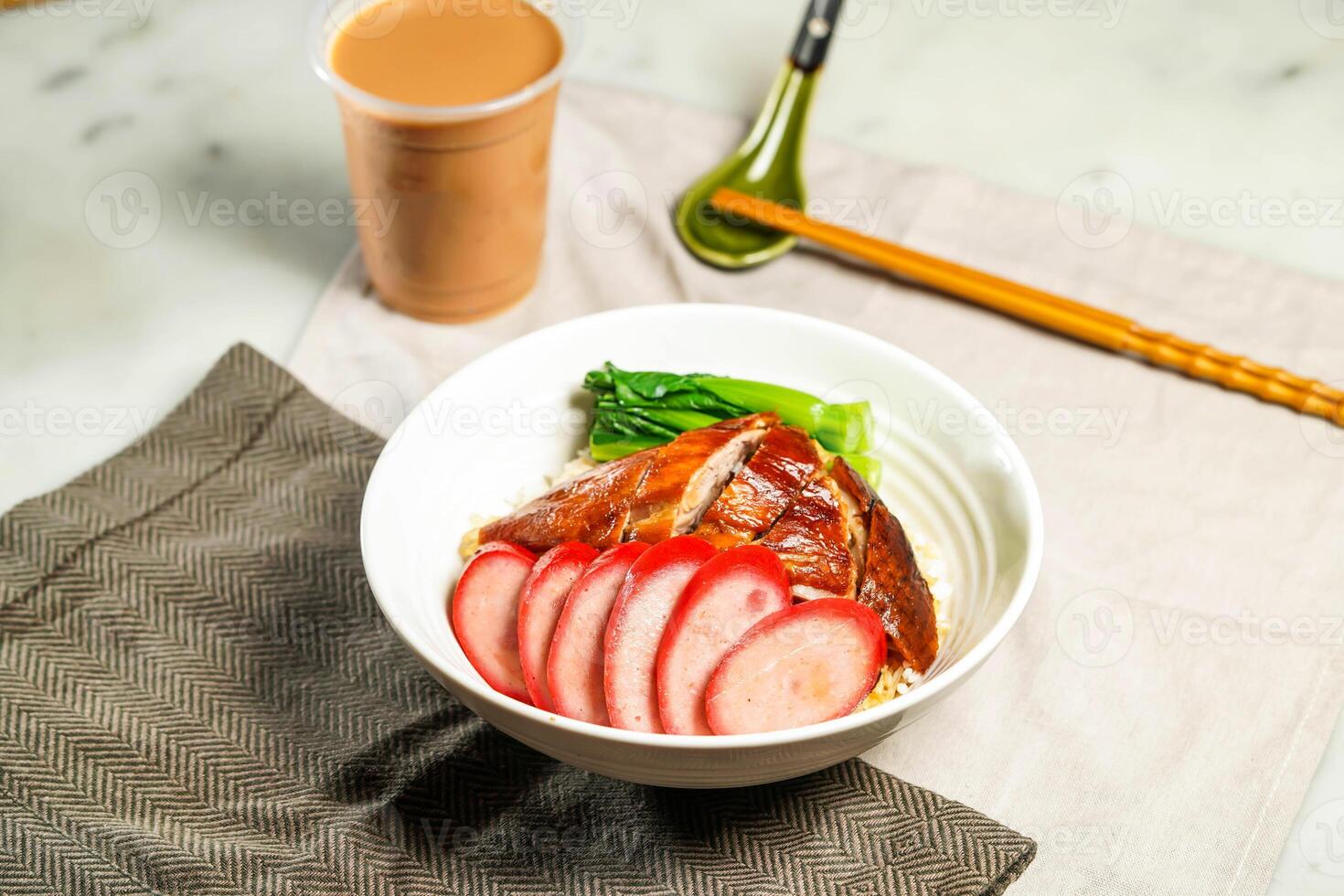 Chinese Sausage and Roasted Duck with Rice with milk kopi chopsticks and spoon served in bowl isolated on napkin side view of hong kong food on marble background photo