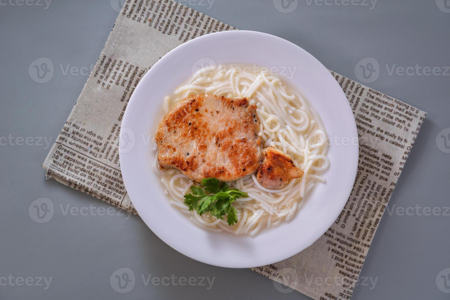 barbeque pork noodles served in dish isolated on napkin top view of chinese food on grey background photo
