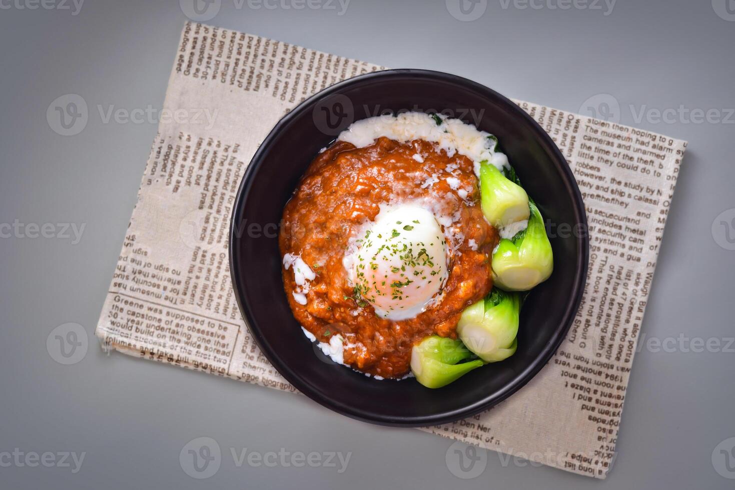 Hot spring egg and beef rice served in bowl isolated on napkin top view of chinese food on grey background photo