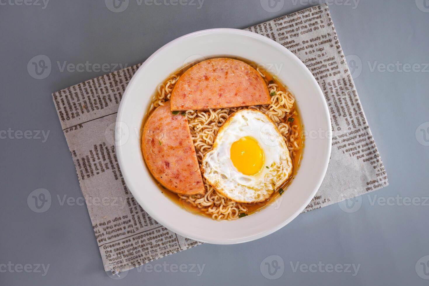 beef, sunny side up fried egg and instant noodle served in dish isolated on napkin top view of chinese food on grey background photo