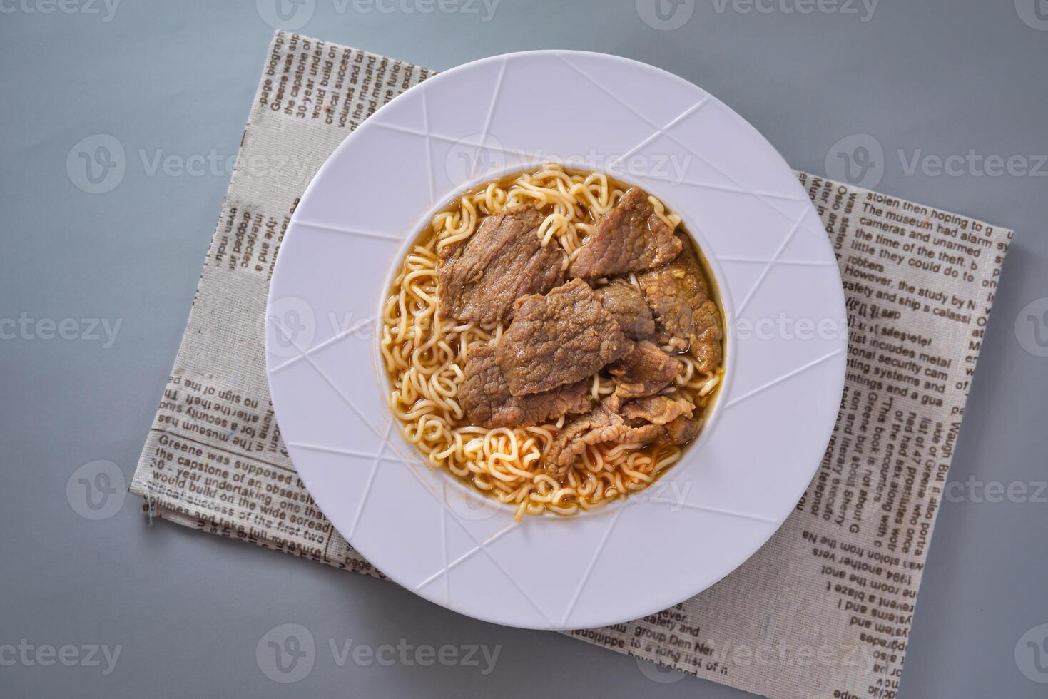 Breakfast Satay beef doll instant noodles served in dish isolated on napkin top view of chinese food on grey background photo