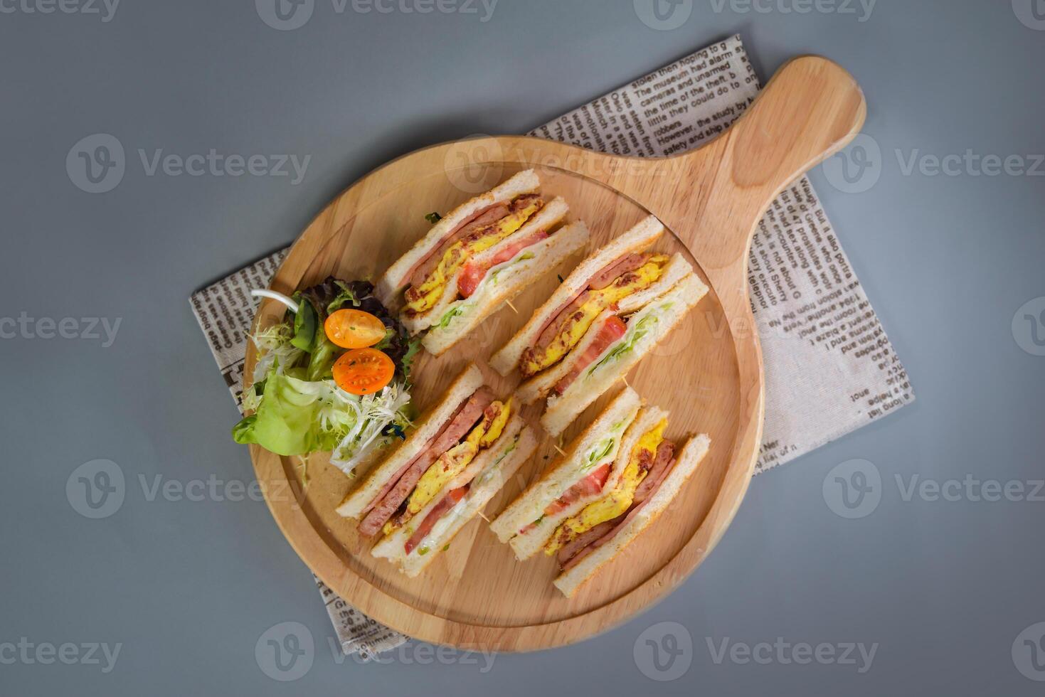 office club sandwiches with salad served in wooden board isolated on napkin top view of chinese food on grey background photo