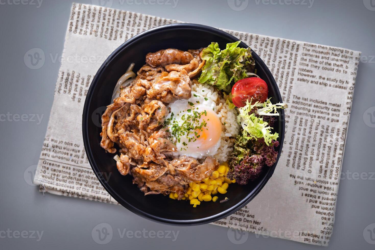 Japanese beef hot spring egg rice bowl with corn and salad served in bowl isolated on napkin top view of chinese food on grey background photo