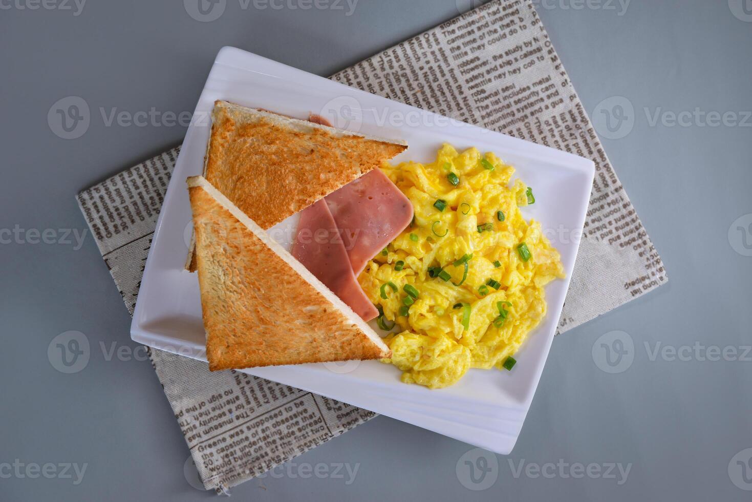 Fried egg toast with chopped green onion and ham breakfast served in dish isolated on napkin top view of chinese food on grey background photo