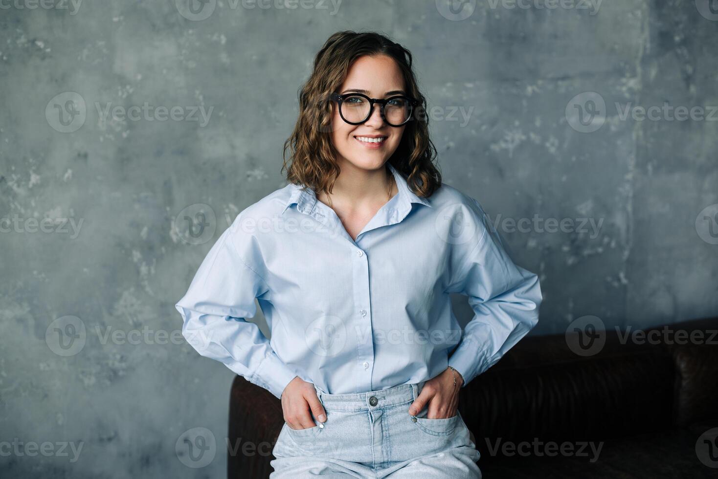 Portrait of a confident young businesswoman smiling while looking out of a window. Ideal for themes of leadership, motivation, and professional aspirations. Captures a moment of contemplation photo