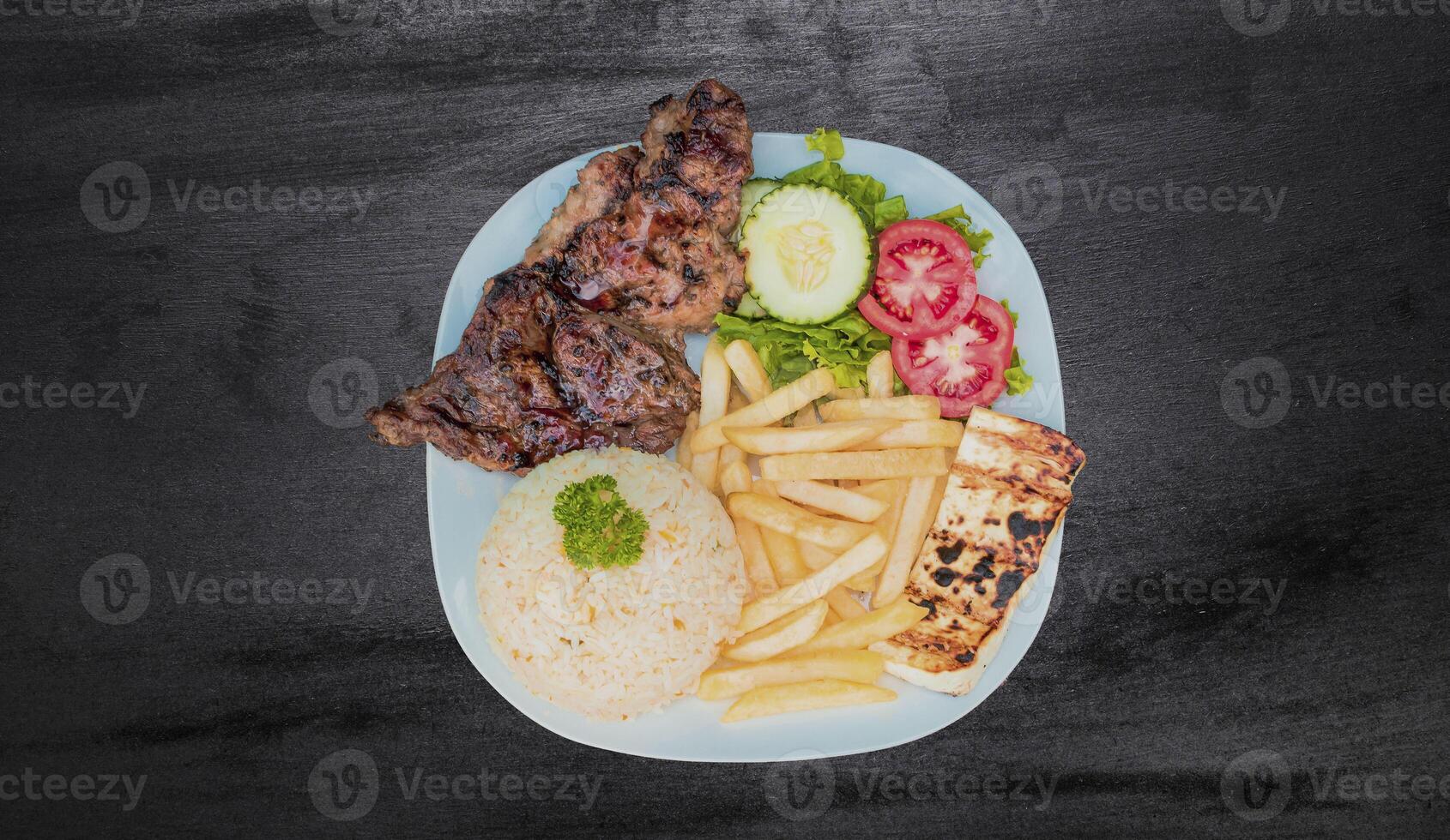 Plate of roasted chicken with rice and french fries on wooden table, Top view of plate of roasted chicken with rice and french fries served, Typical Nicaraguan food roasted chicken with french fries photo