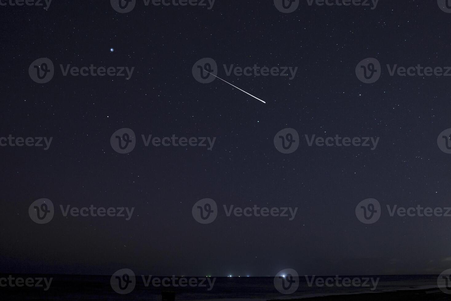 Beautiful meteors in the night sky over Latvia. Night landscape with shooting stars. Falling meteorites. photo