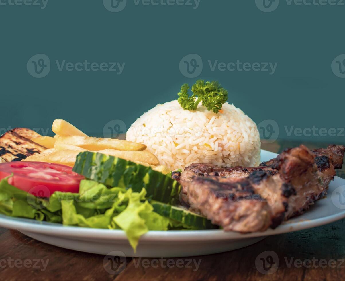 Roast chicken close-up with tomato salad and french fries, Roast chicken traditional food served on wooden table, plate with roasted chicken and rice served on wooden background photo