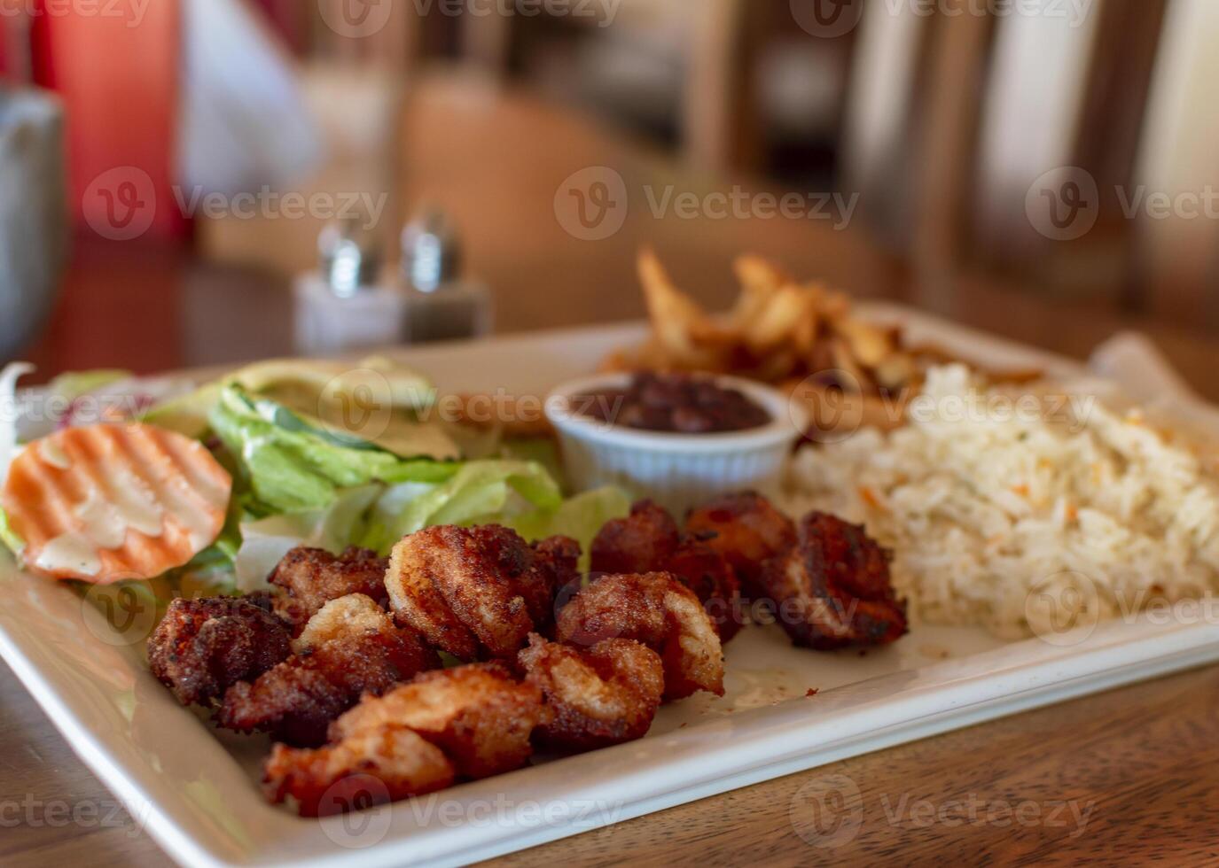 Plate of breaded shrimp with rice on the table with COPY SPACE, menu of breaded shrimp served on wooden table photo