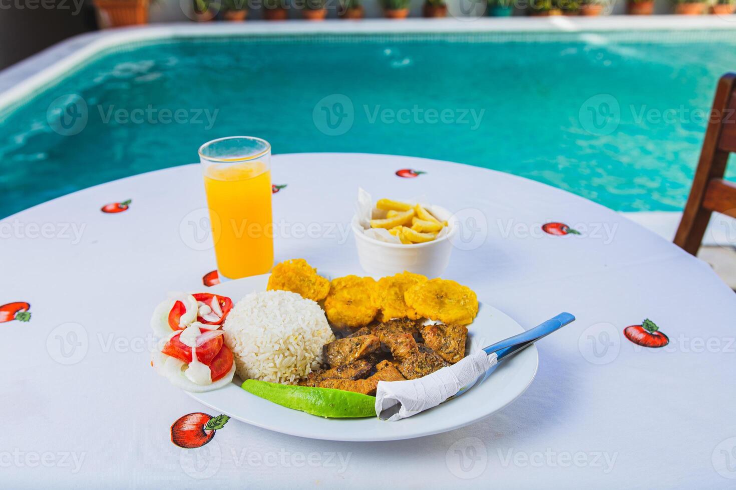 Delicious breakfast near a crystal clear pool. Traditional breakfast with orange juice served near a swimming pool photo