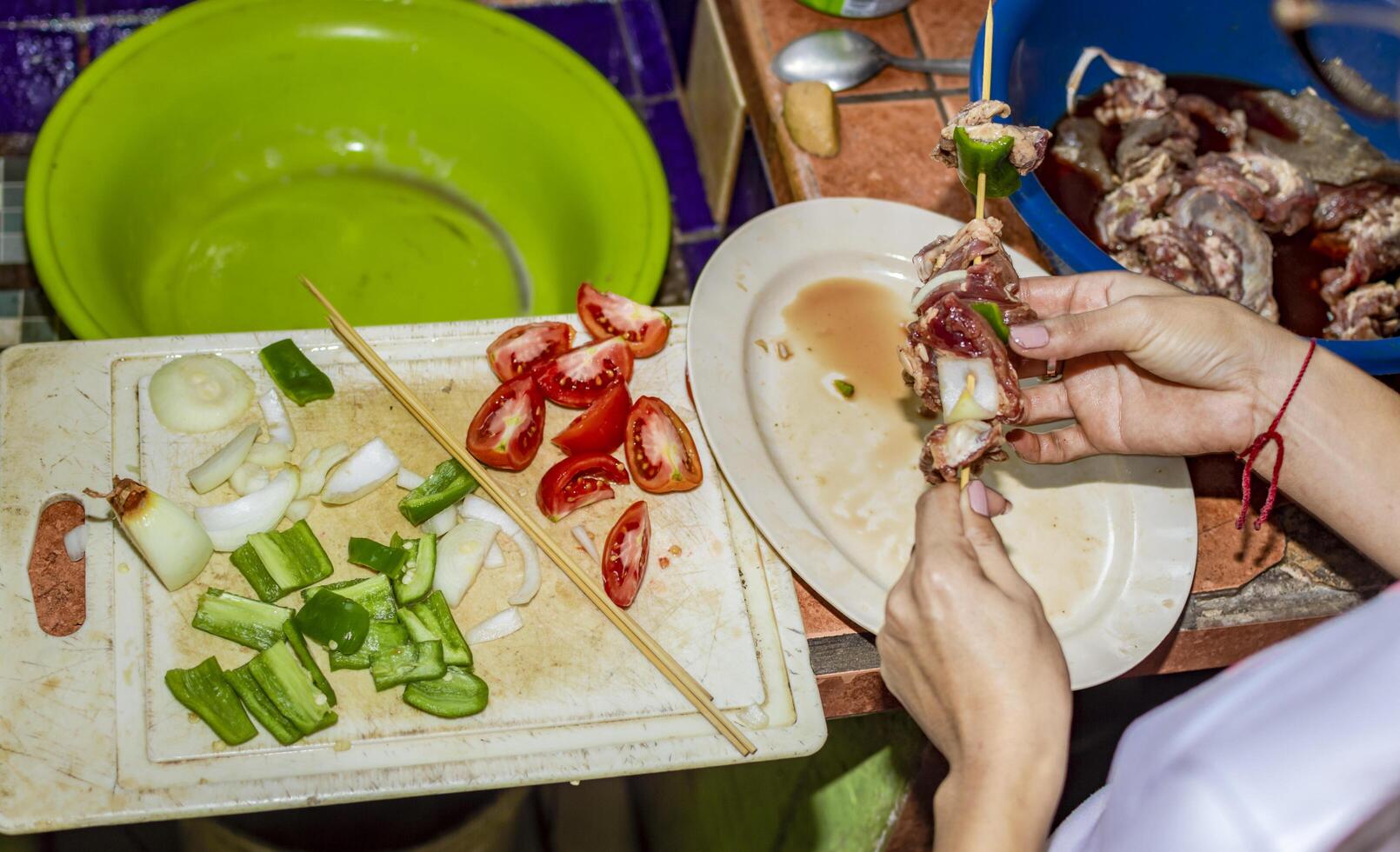 A person preparing roast beef skewers, close up of hands preparing meat skewers photo