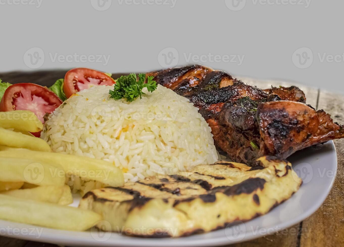 Pork rib with rice, fried cheese and salad served on the table, Close up of Pork rib with salad and French fries served on wooden table, Top view of plate of fresh Pork rib served on the table photo