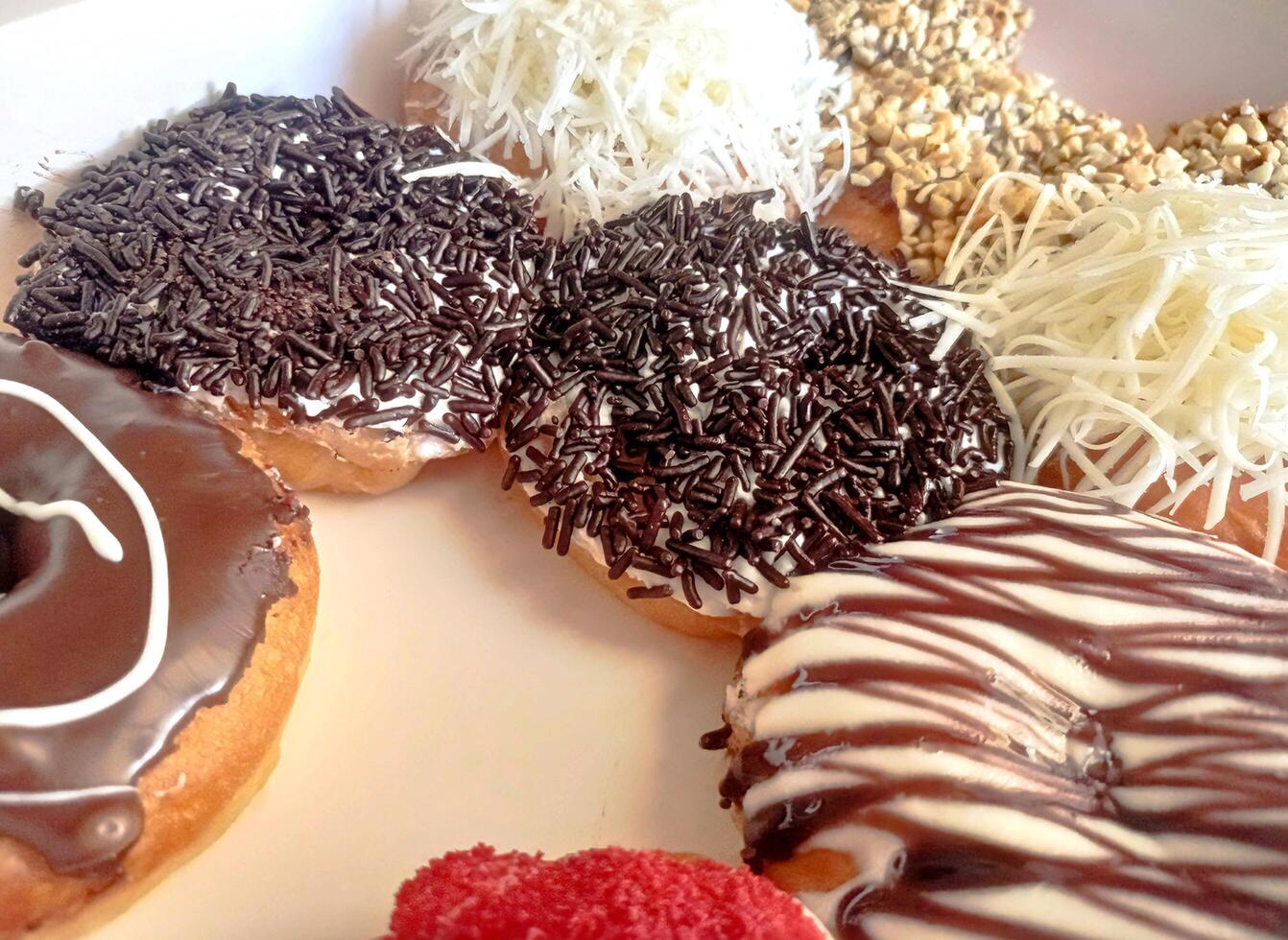 a plate of donuts with chocolate and sprinkles photo