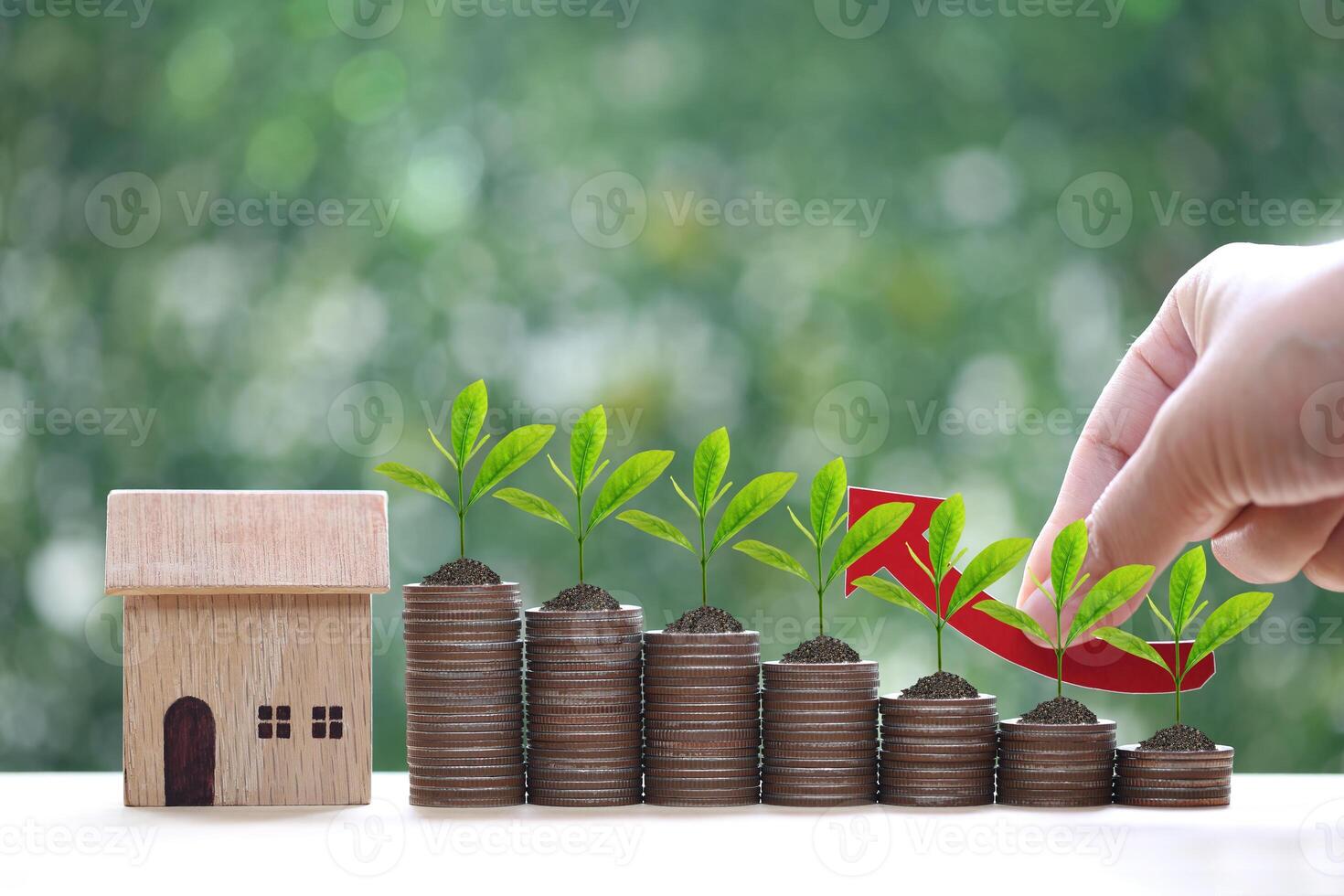 Mortgage,Model house and stack of coins money on natural green background,Business investment and real estate concept photo