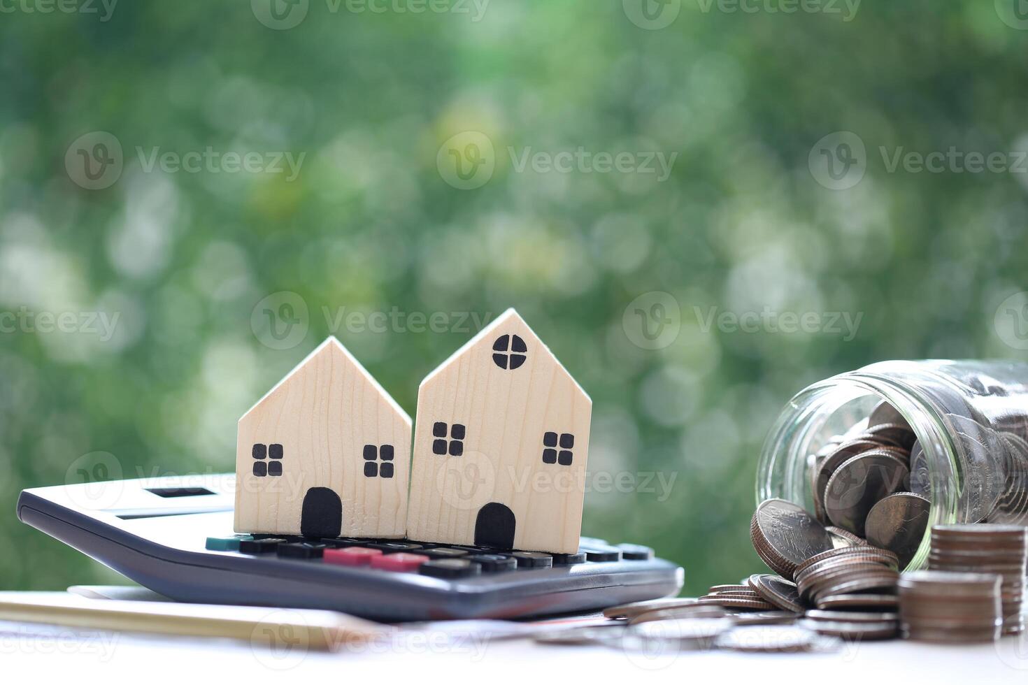 Model house on calculator with stack of coins money on natural green background, Calculating interest payments and Property tax concept photo
