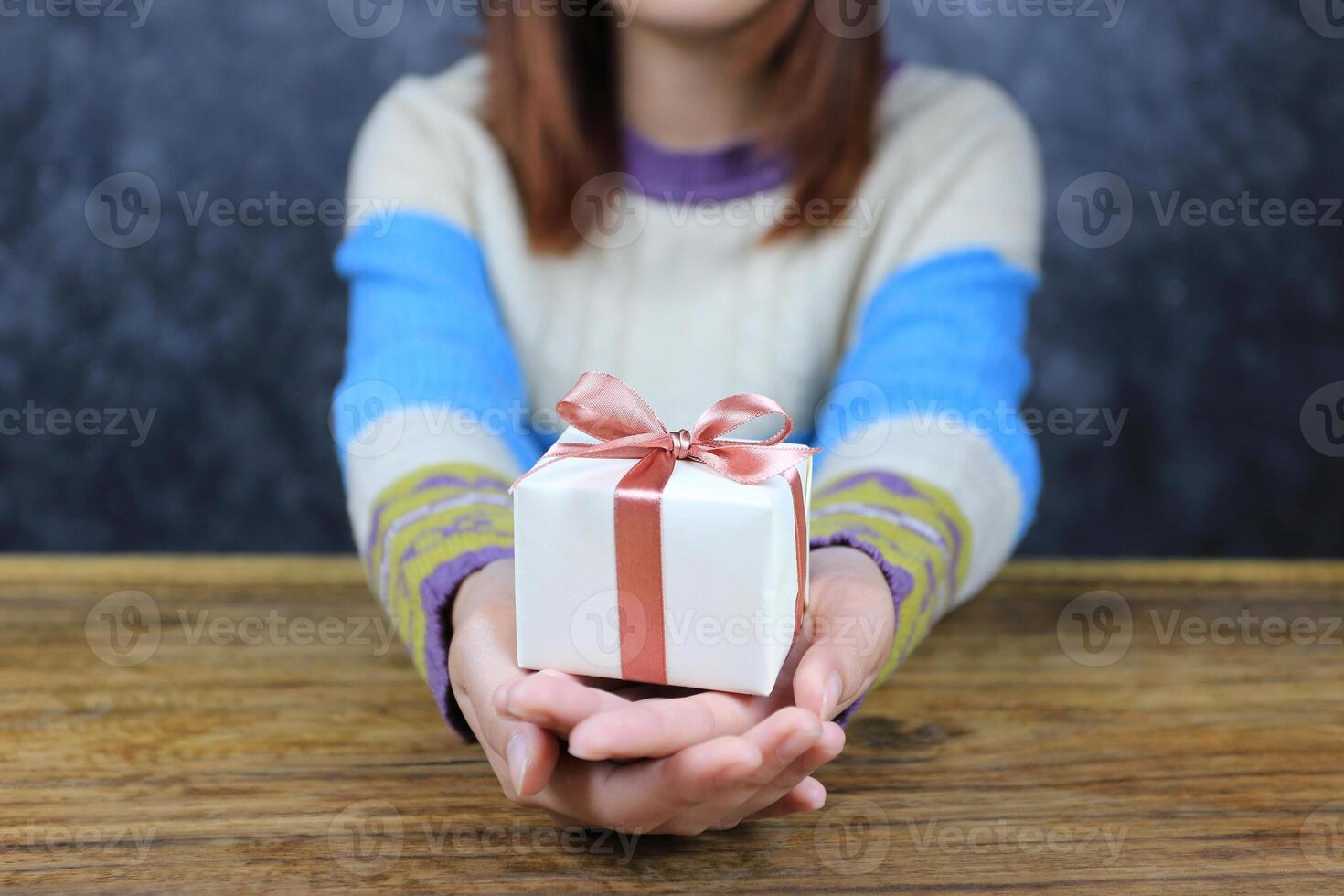 Selective focus of Woman hand holding gift box with red ribbon for Christmas and New Year's Day or Greeting season photo