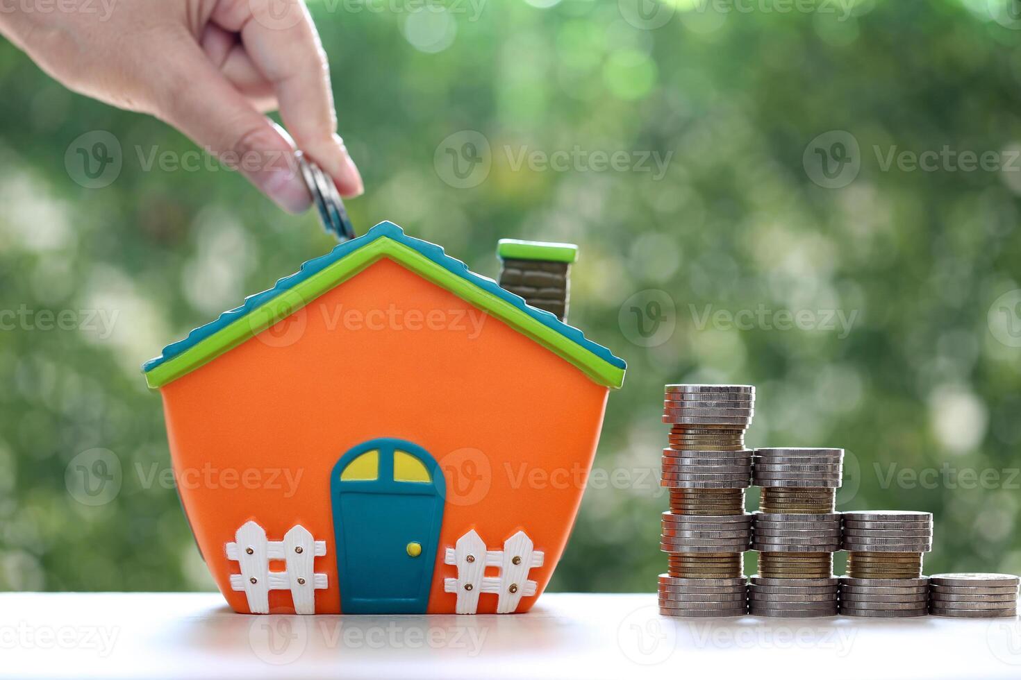 Finance, Model house and Stack of coins money on natural green background, Business investment and real estate photo