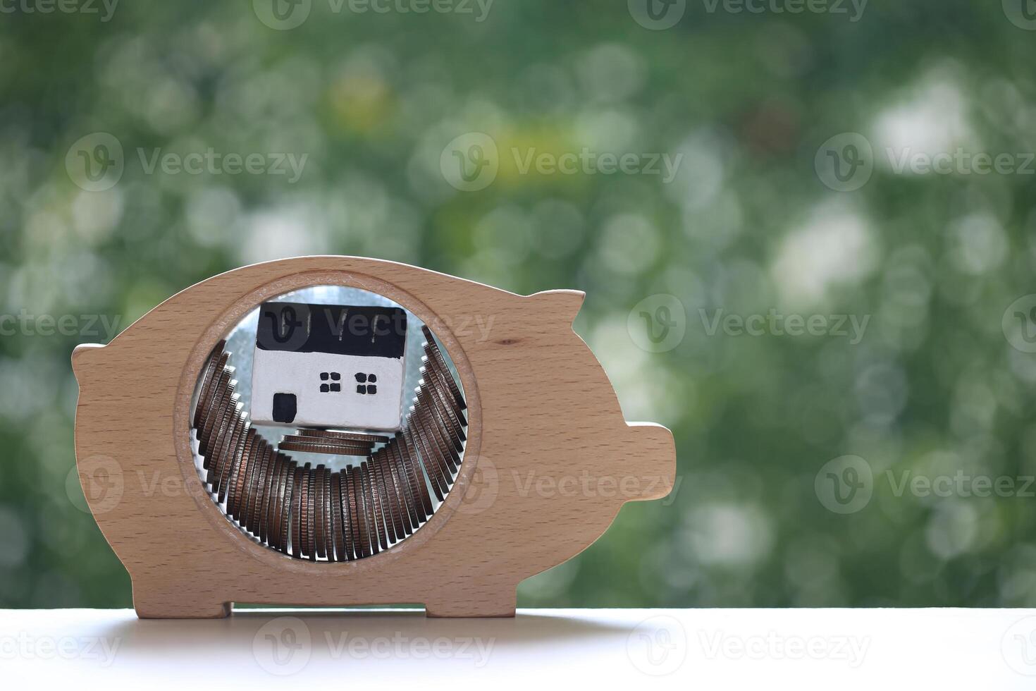 Model house in piggy bank on natural green background, Save money for prepare in future and real estate concept photo