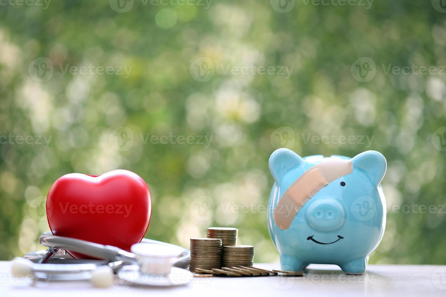 Piggy bank with stethoscope and red heart on green background,Save money for Medical insurance and Health care concept photo