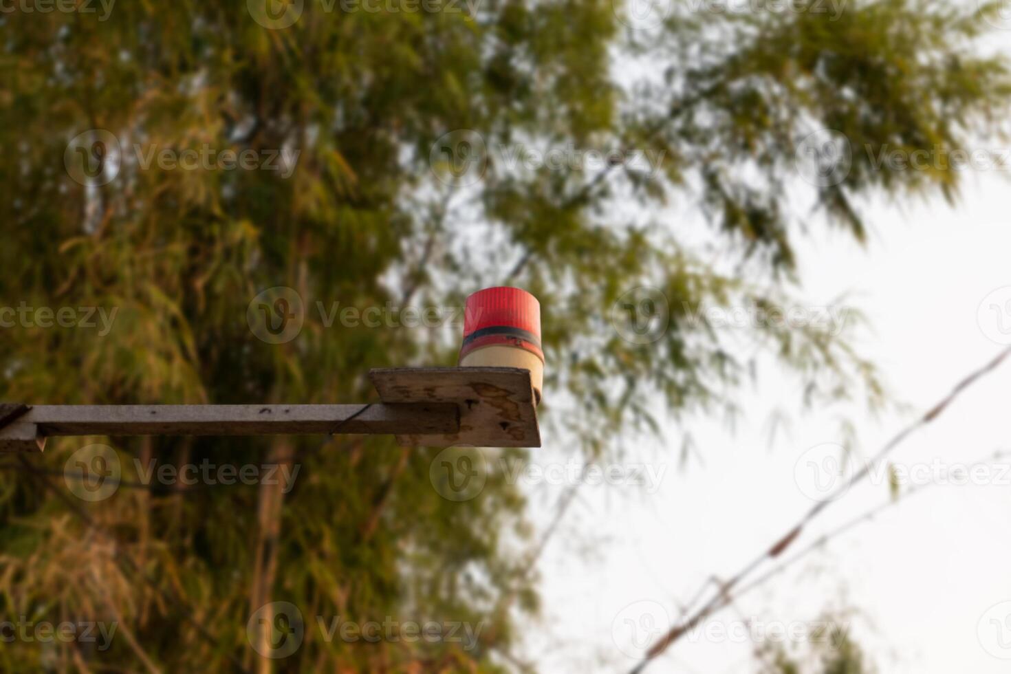 a red and white beacon flashing on a metal pole photo