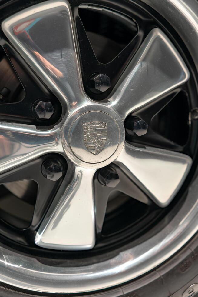 Stuttgart, Germany, August 13, 2023. The Porsche logo is a close-up on the wheel of the car. photo