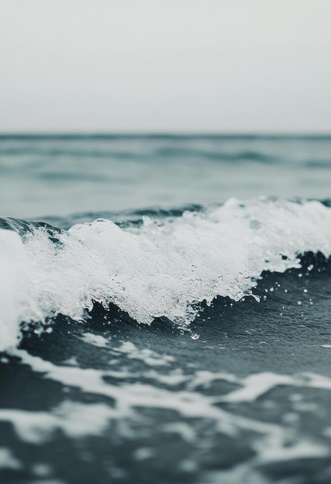 Gentle waves lap against the shore at sunset on a serene beach photo