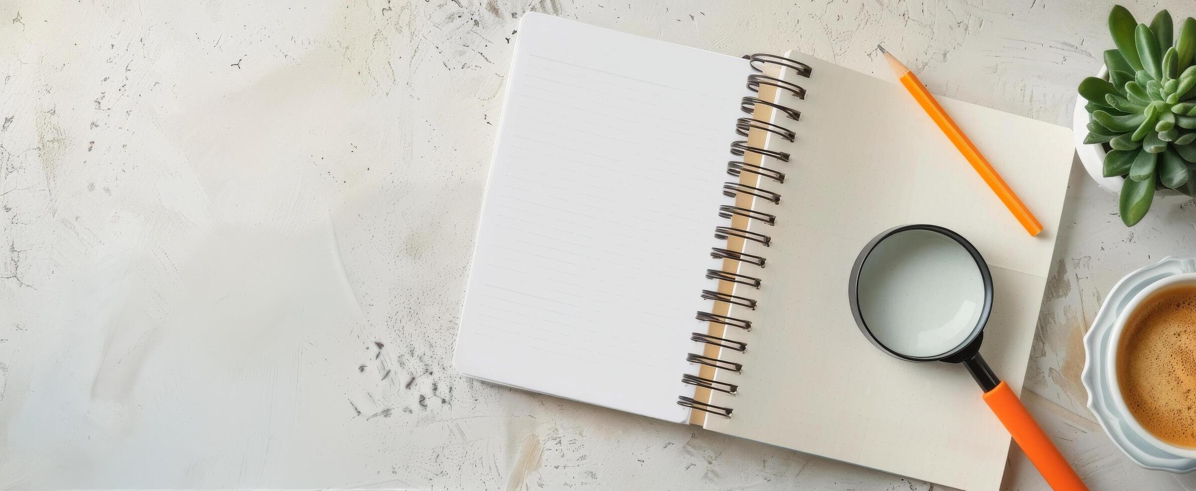 Open Notebook With Magnifying Glass, Orange Pen, Coffee, And Succulent Plant On Table photo