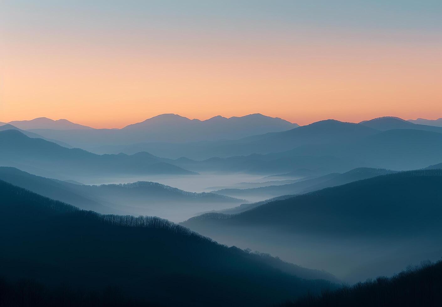 Serene Mountain Range at Dawn With Soft Mist and Gentle Hues photo