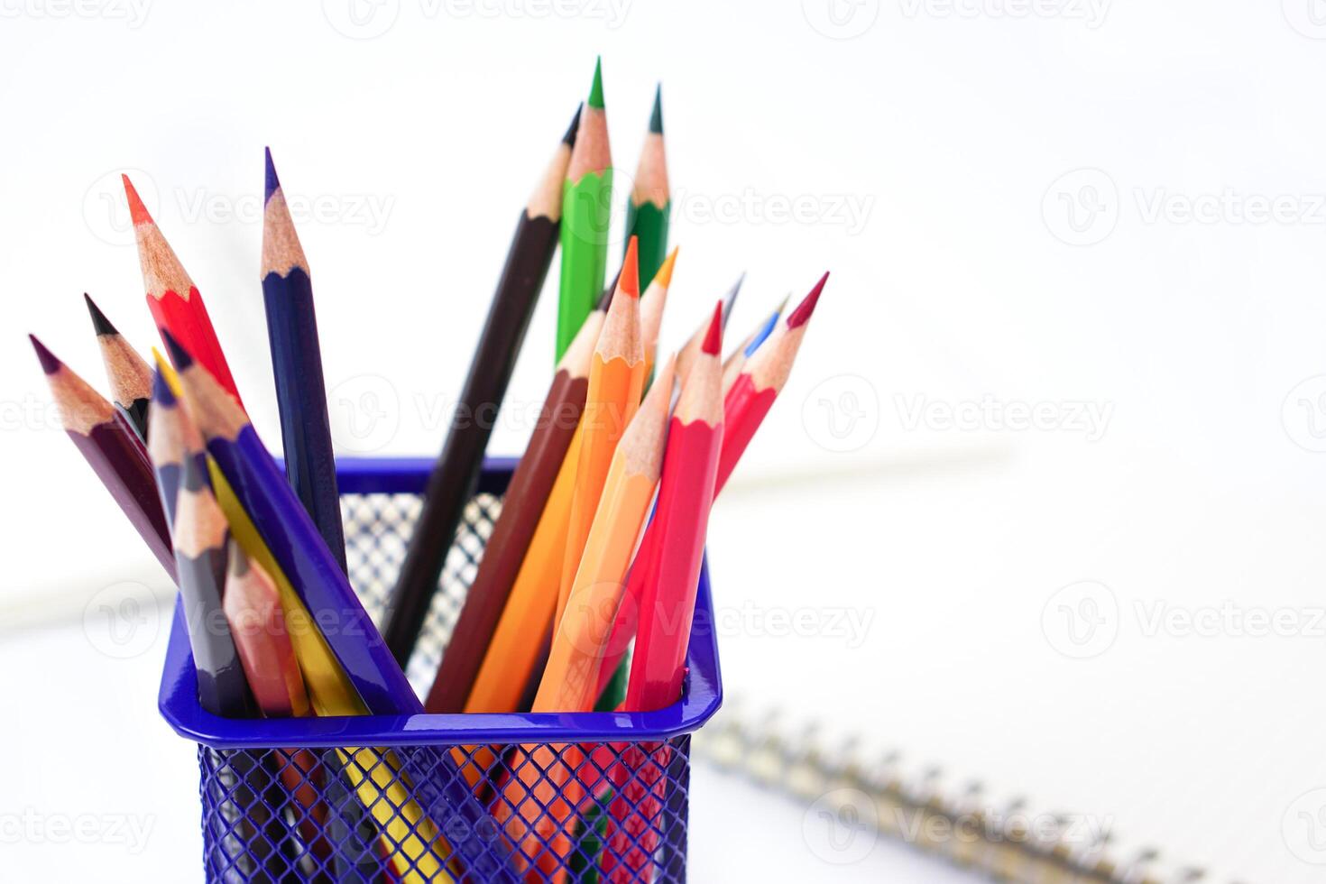 Selective focus, Crayon or colored pencils in box and the book placed in the blurred background. Muticolor, school supplies and art supplies concept. photo