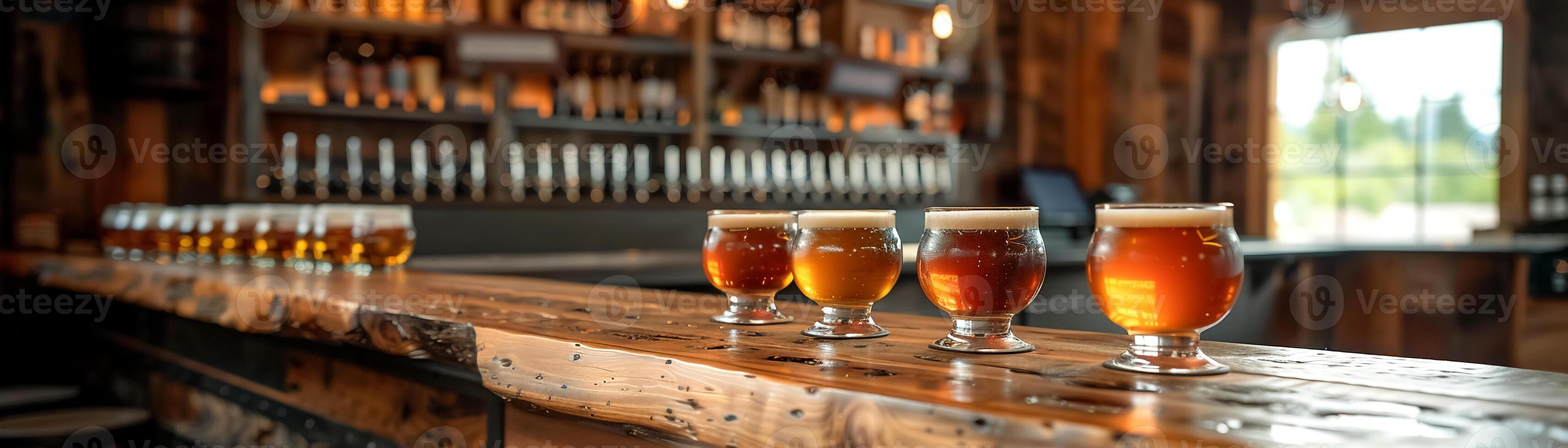 The row of craft beers in various colors on a rustic wooden bar counter inside a cozy brewery setting photo