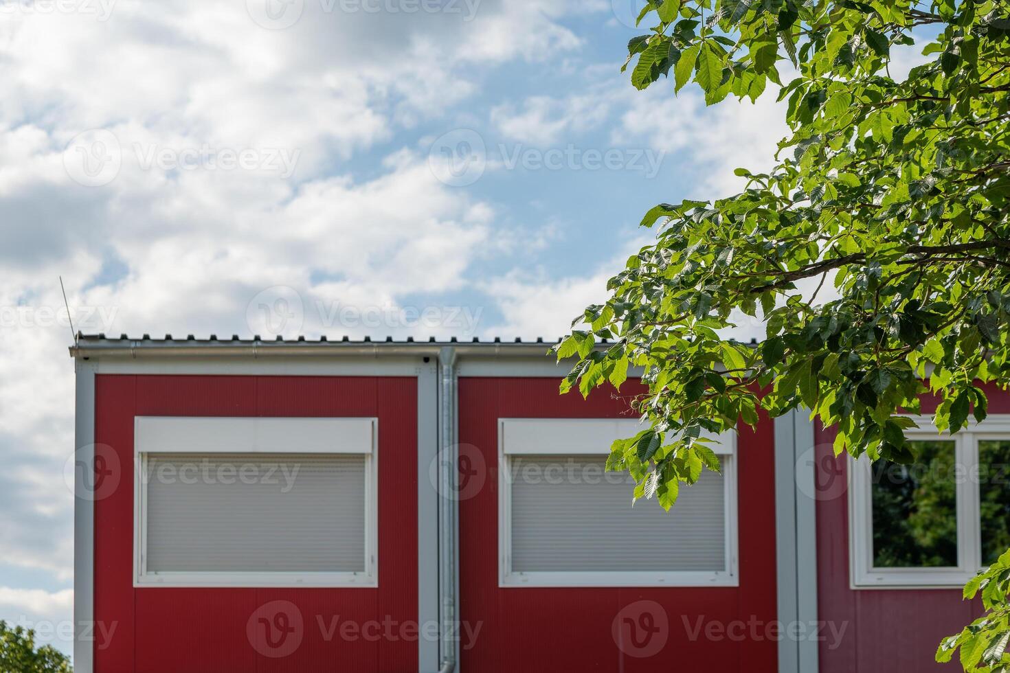 red building with a white roof and two windows photo