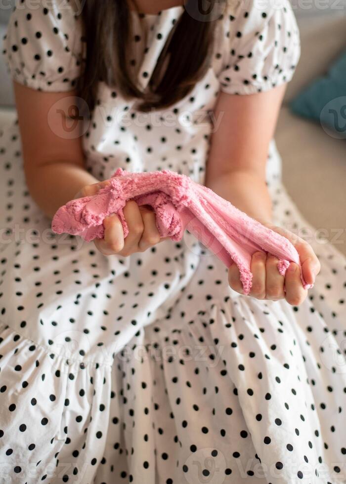 Girl Stretching Slime. Girl Playing with Pink Slime photo