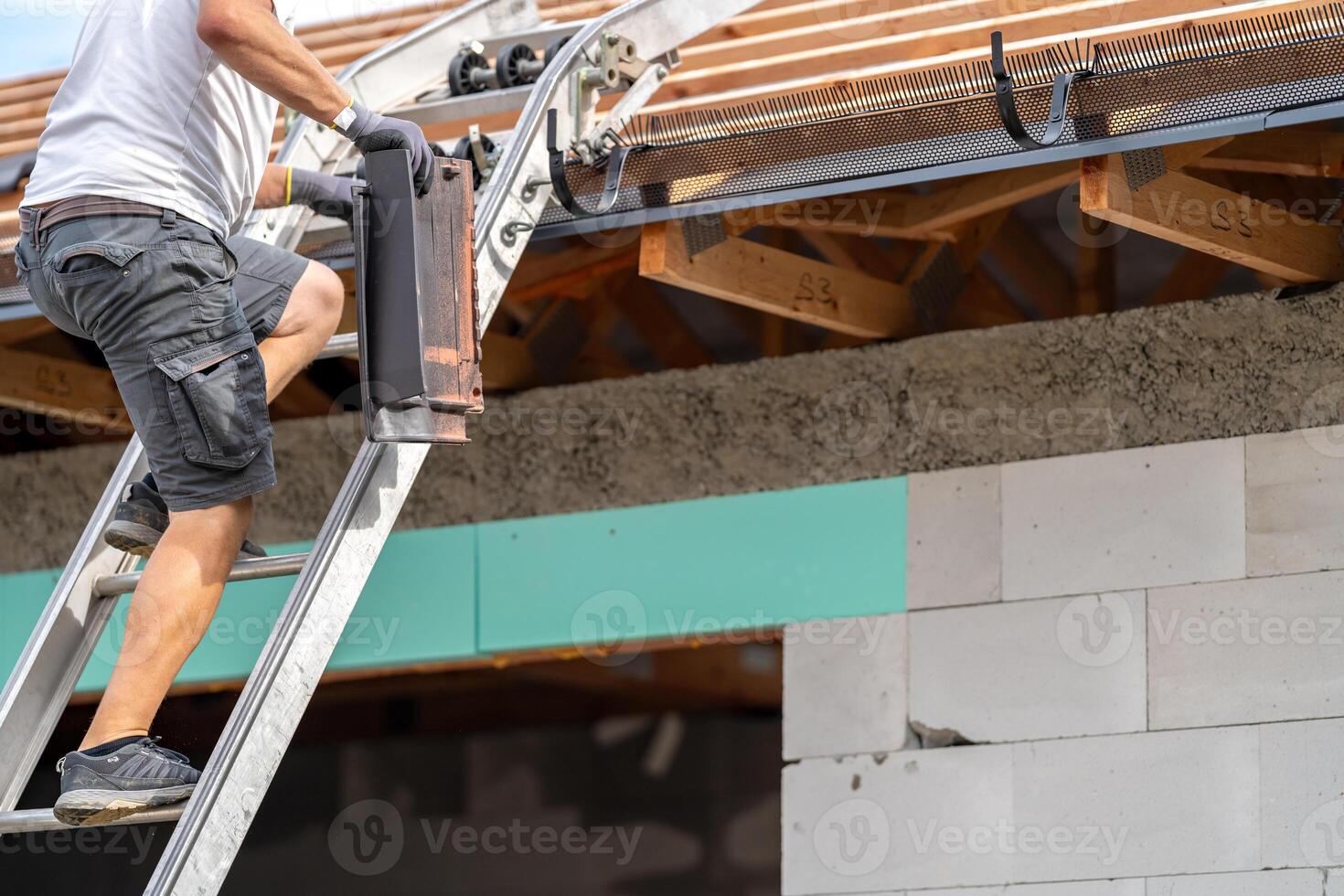 a worker carries a ceramic tile up the stairs to the roof photo