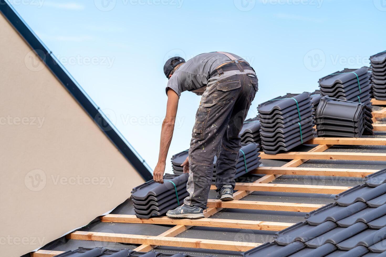 new roof of a family house, a roofer builds a roof made of ceramic tiles photo
