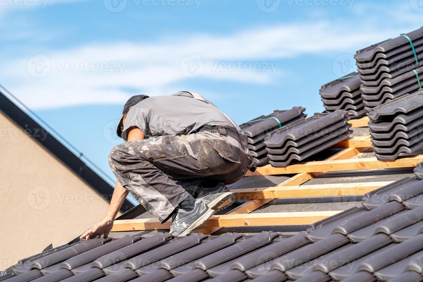 installation of ceramic tiles on the roof of the building by an expert photo