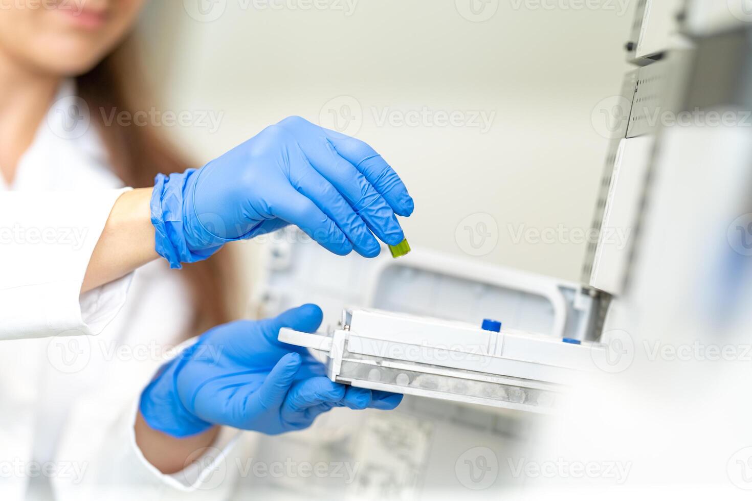 conducting chemical experiments in modern devices in a research laboratory. inserting the container with the solution into the measuring device photo