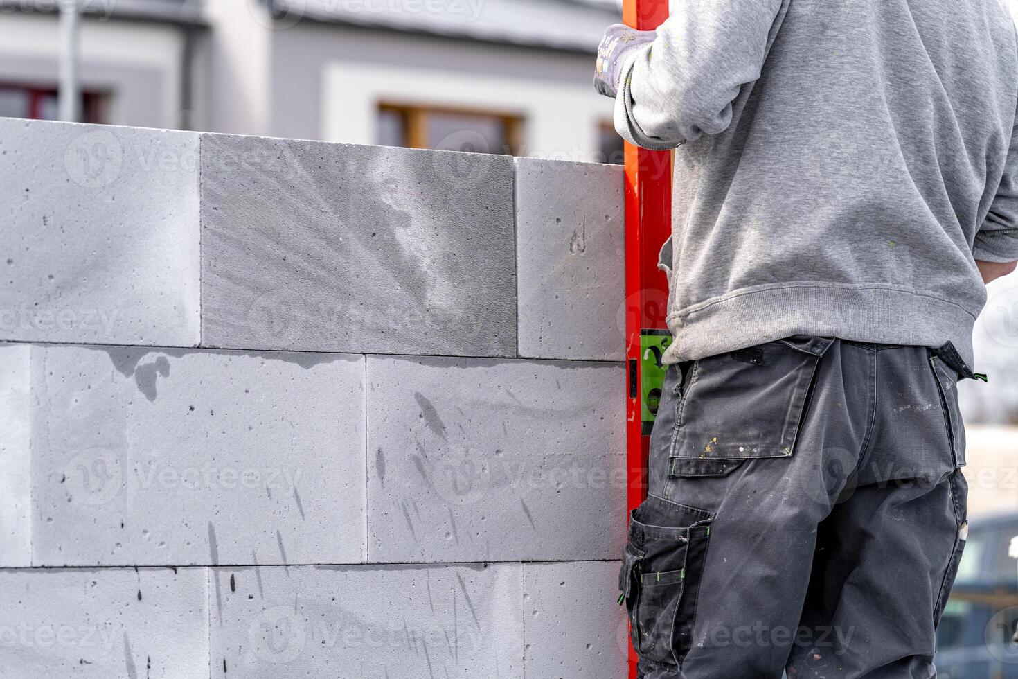 bricklayer leveling bricks with the help of a spirit level during the construction of the wall of the house photo