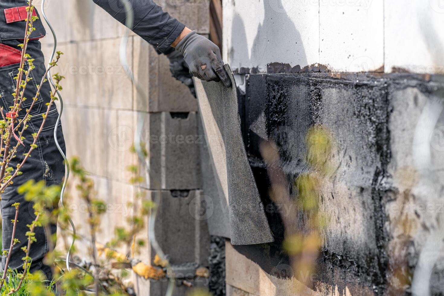 installation of protective waterproofing on the foundation and walls of the building. warmed by an open fire photo