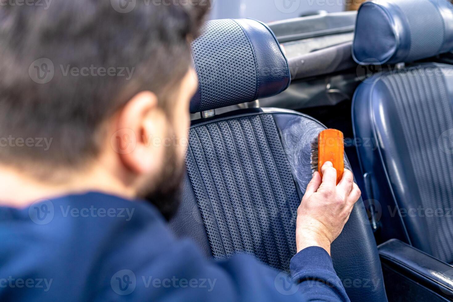 cleaning leather car seats with a brush and chemicals photo