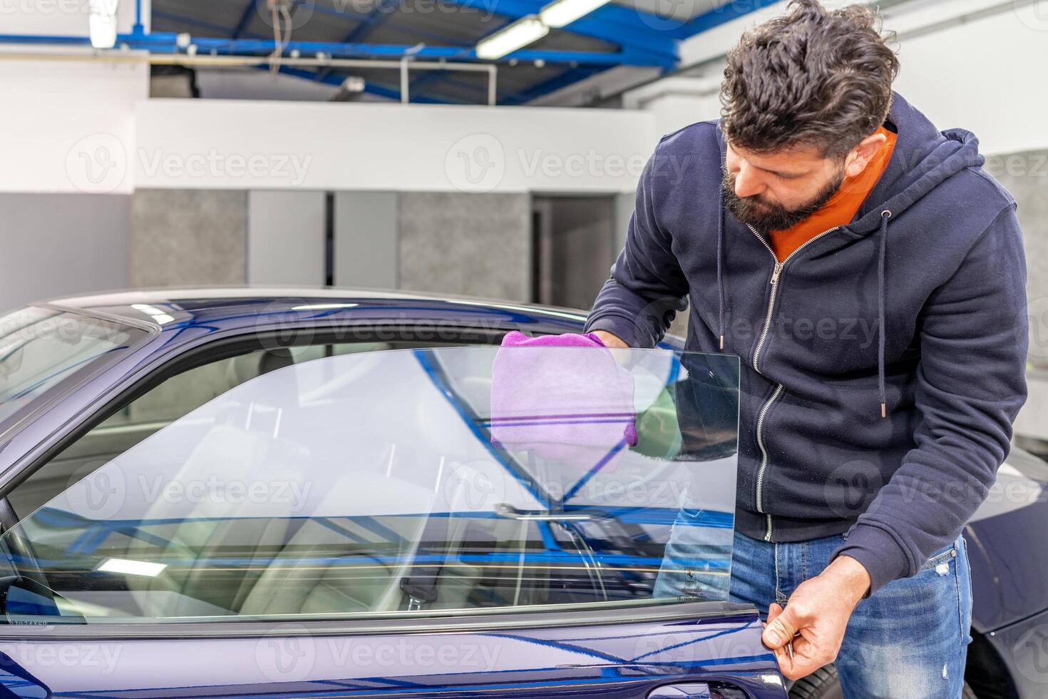 manual cleaning of luxury car windows with a microfiber towel in the garage photo
