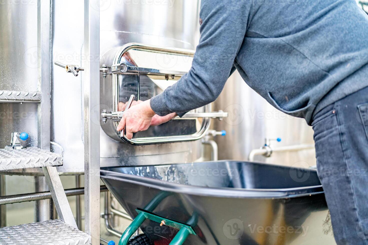 cleaning the boiler from residual malt after brewing beer in the brewery photo