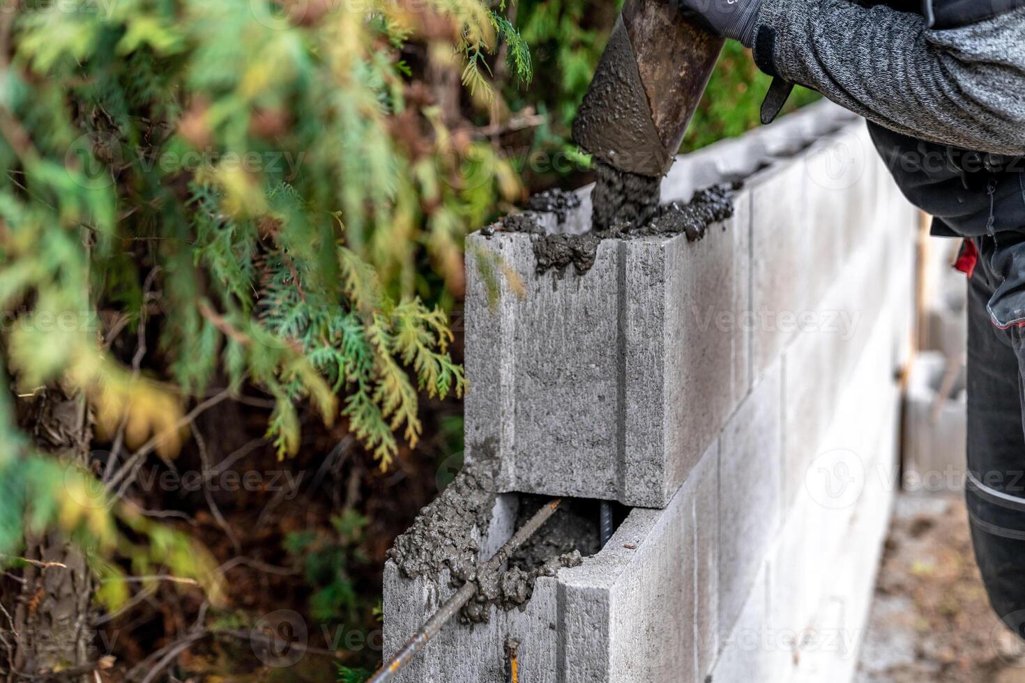 pour concrete from the mixer of the foundation of the building in the ground photo